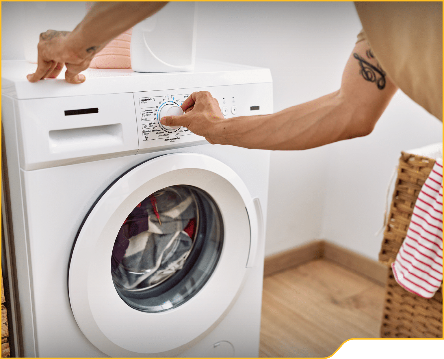 Young hispanic man using washing machine at laundry room