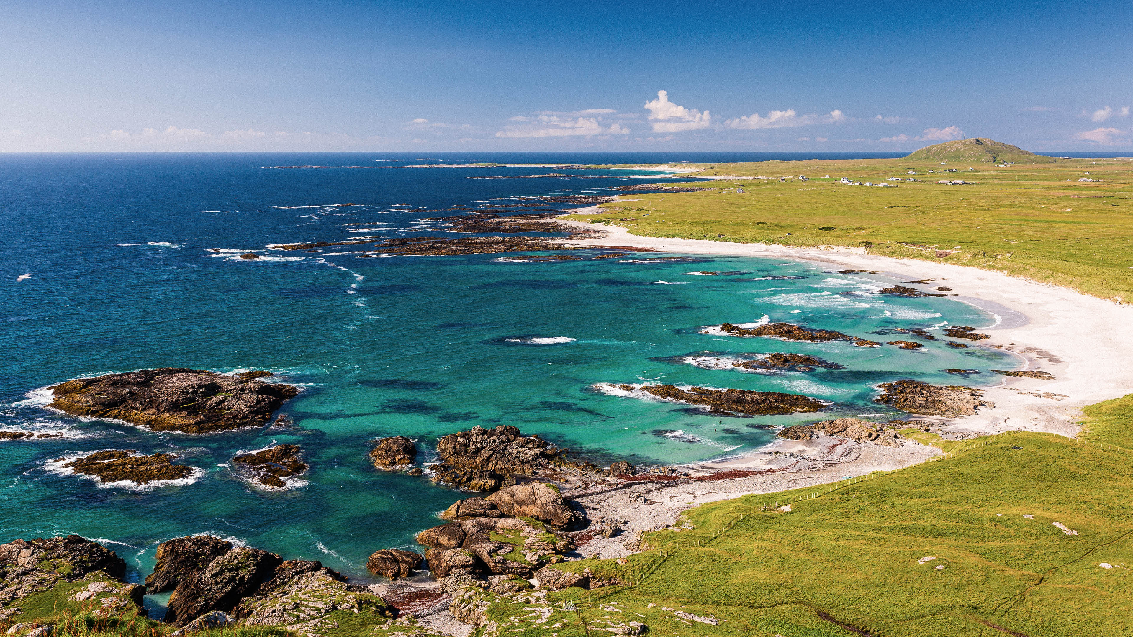 A beautiful beach with a rocky shoreline. Description generated by AI
