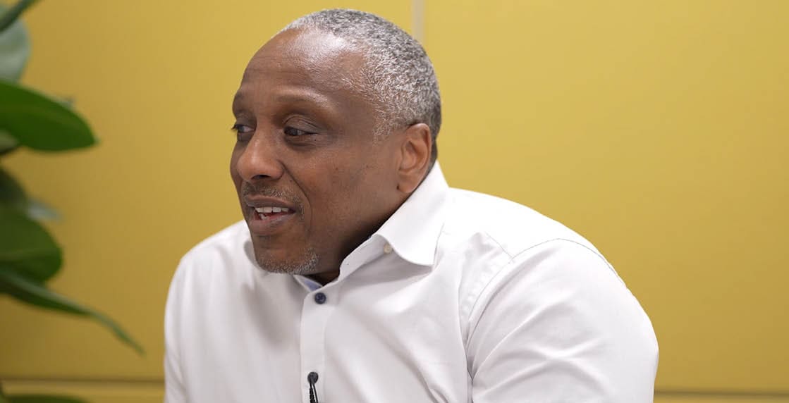 A man wearing a white shirt and a black microphone. Description generated by AI
