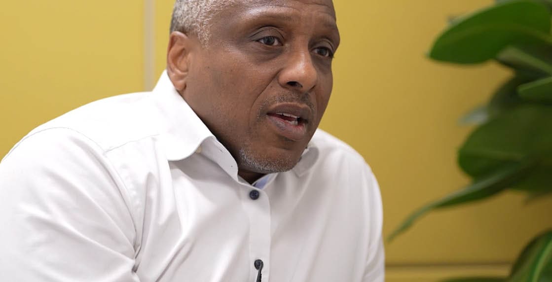 A man wearing a white shirt and a microphone. Description generated by AI