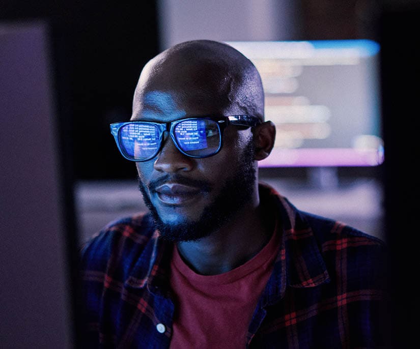 Cyber security, black man and code reflection in eyewear, hacking and software update in office. African American male employee, programmer or IT specialist with glasses, focus and cloud computing