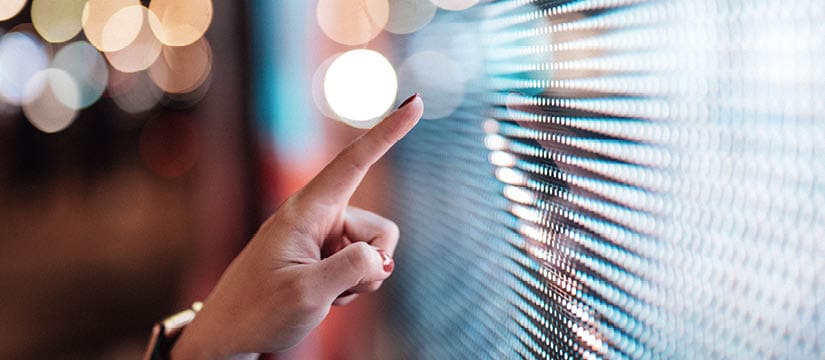 Female hand touching illuminated digital display in the dark. Connecting to the future. Lifestyles and technology. Smart city concept.